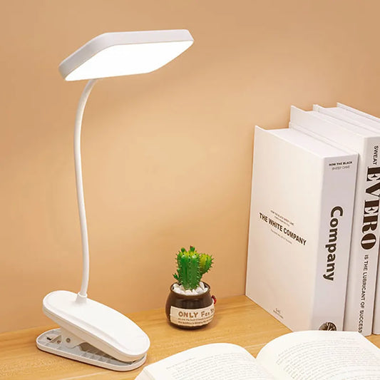 A product image of the 360° Lamp on a desk lighting a book